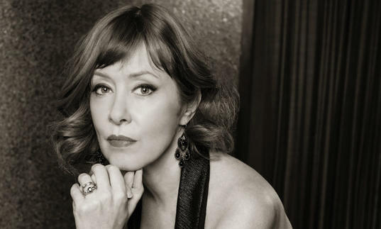 black and white photo of suzanne vega. resting her chin on her hand.