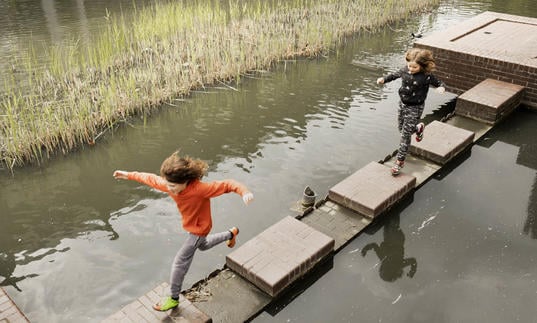 Child jumping on lakeside