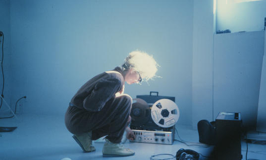 A woman kneels down in front of a recorder