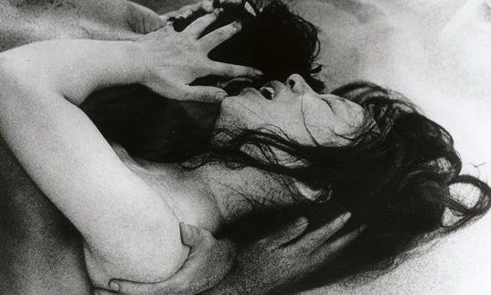 black and white photo of a japanese woman on the floor embracing someone else