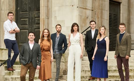 The members of Voces 8, standing on some steps