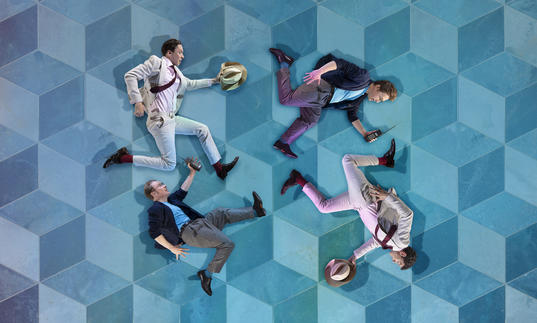 Four cutout images of running men in suits are placed on a blue Escher style tiled background.