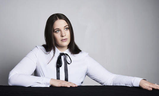 Lise Davidsen sitting at a table with her arms on it, gazing out into the distance
