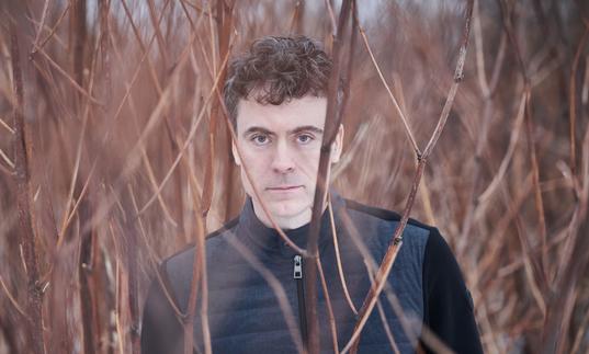 Paul Lewis standing in some blurred out reeds