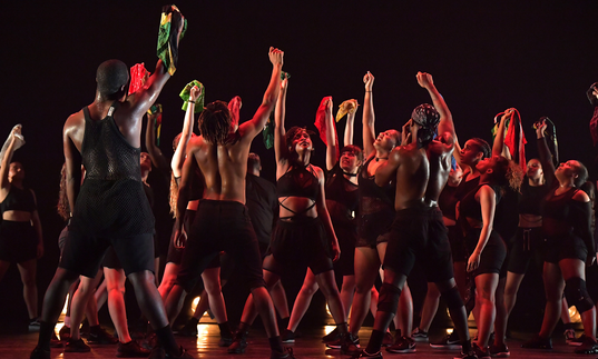 Dancers on stage with raised fists