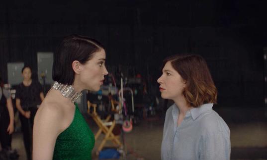 Annie Clark (St Vincent) and Carrie Brownstein (Sleater-Kinney) look at each other in portrait in a still from The Nowhere Inn