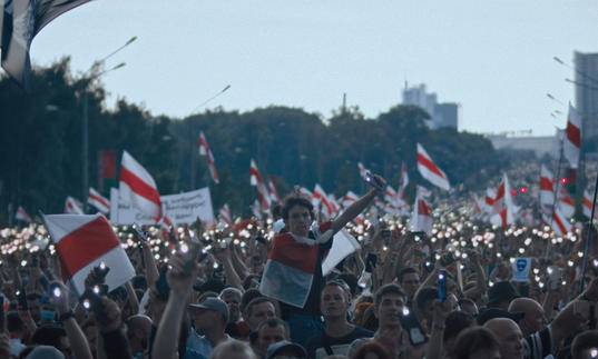 A crowd of people in Belarus waving the countries flag