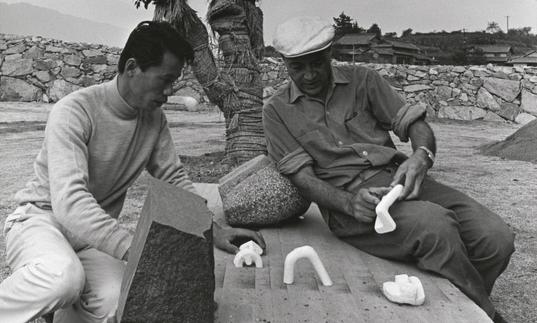 Isamu Noguchi studying models with Masatoshi Izumi in Mure, Japan, c.1970s