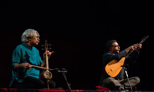 Kayhan Kalhor and Erdal Erzincan performing on stage with instruments