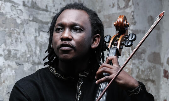 Abel Selaocoe holding his cello