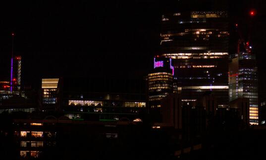 Buildings around the Barbican lit up at night time.