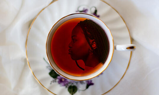 Image of a girl's face in profile in a china teacup