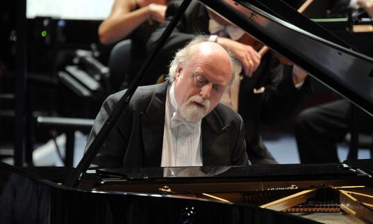 Peter Donohoe playing the piano on stage