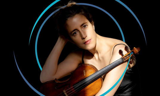 Vilde Frang holding her violin, with circular blue swirls around her
