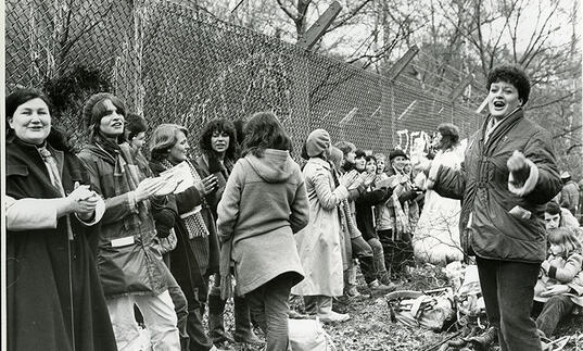 Format Photographers (Sheila Gray) Women singing at the Embrace the Base weekend of action, Greenham Common, 12 December 1982 © Sheila Gray / Format Photographers Archive at the Bishopsgate Institute, London. Courtesy the Bishopsgate Institute, London.