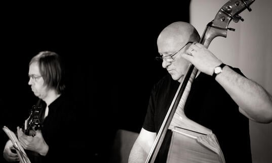 Black and white photo of Gavin Bryars playing the double bass and James Woodrow on the guitar