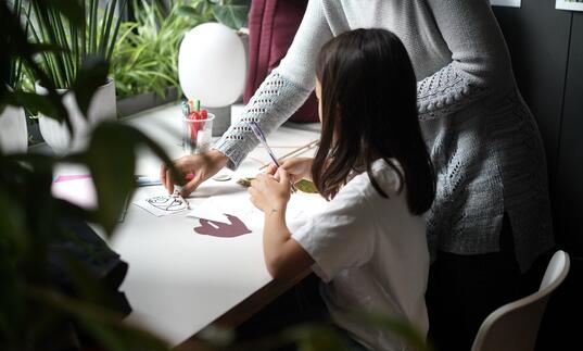 A young girl makes arts and crafts in the Barbican Cinema Cafe.