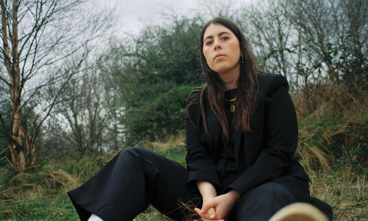 Sorcha Richardson sits in the middle of a woodland clearing