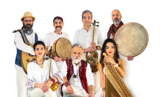 Rastak sit in all white outfits with their selection of instruments
