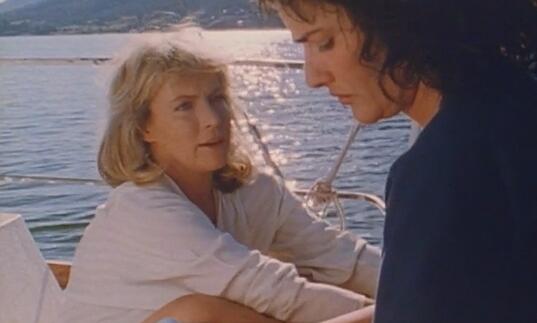 Two women chat on a boat on a glorious, sunny Mediterranean ocean. 