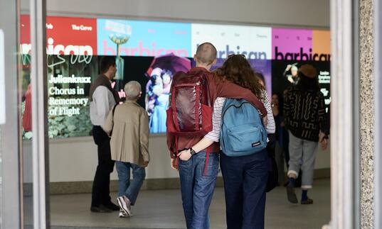 Image of couple walking into the Barbican entrance