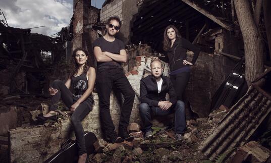 The Carducci Quartet sitting amongst the ruins of a brick building