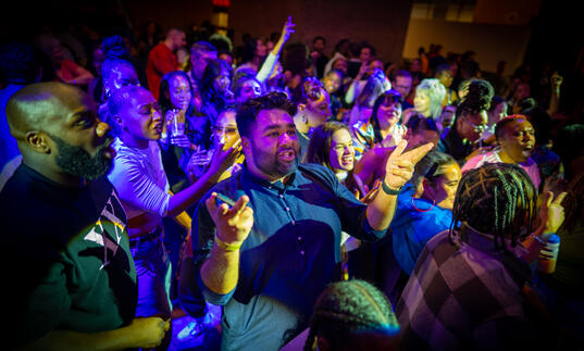 A group of people move on the dance floor to music.