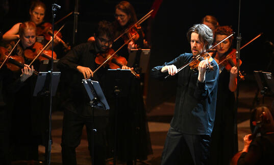 Britten Sinfonia on stage, playing violins