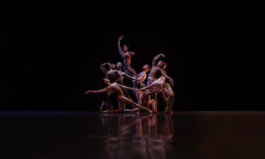 Members of the Ballet Black ensemble pose together, they move fluidly between and around one another.