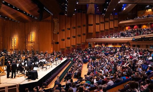 The London Symphony Orchestra on the Barbican Hall stage in front of a full audience of families