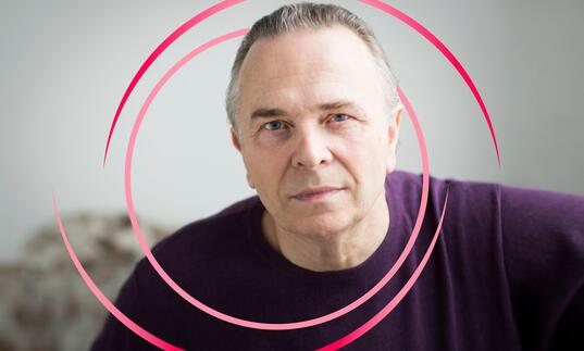 A photo of Mark Elder with pink circular swirls around him