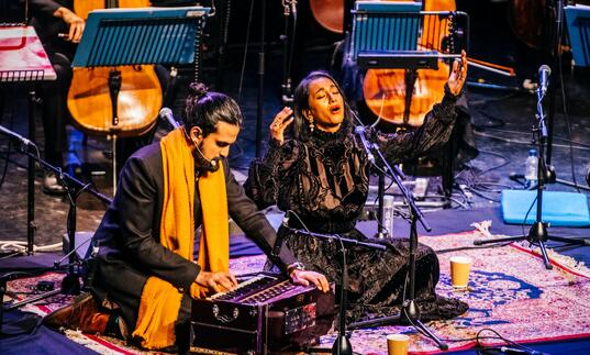 Rushil Ranjan and Abi Sampa sitting on stage performing