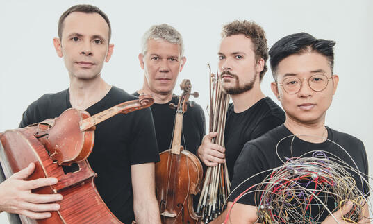 Quatuor Diotima holding broken instruments. 