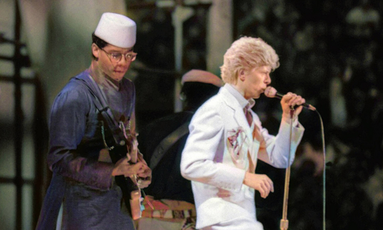Guitarist Carlos Alomar on stage next to David Bowie