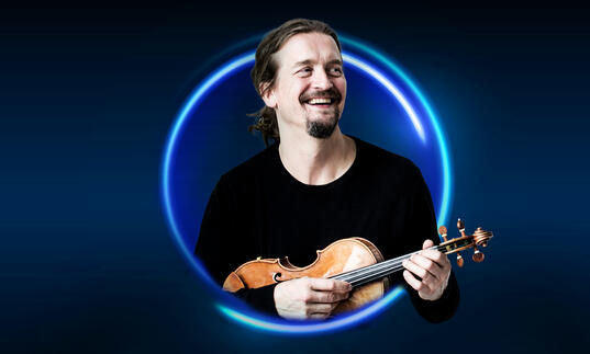 n image of Christian Tetzaff surrounded by a blue circle against a blue background