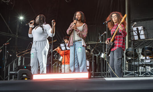 Music Education Islington performance - a trio of young singers and guitar player