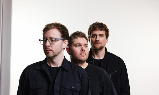 Image of the Manchester trio GoGo Penguin standing next to each other against a white backdrop.