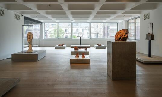 A shot of the Level 2 gallery showing works by Huma Bhabha and Alberto Giacometti on concrete plinths.