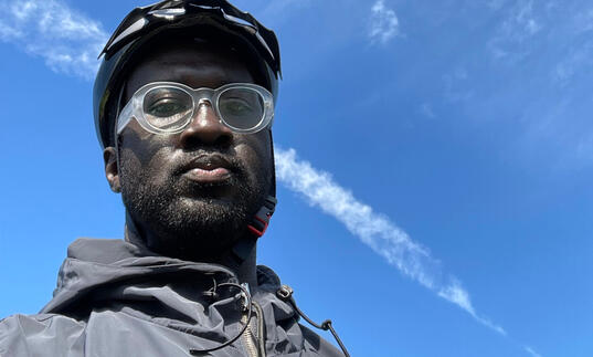Image of Kwes taken from a low angle with the background of the sky