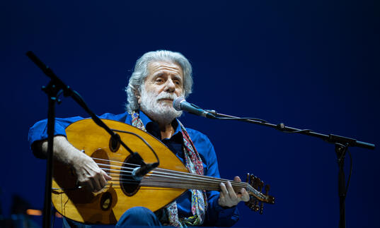 Mid performance shot of Marcel Khalife playing the oud.
