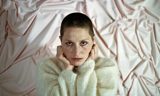Image of Cate Le Bon with her hands on her head