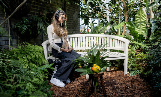 A person sitting on a bench wearing headphones