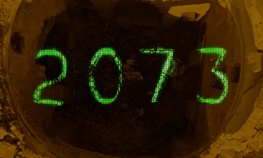 Green writing spells out 2073 over a pile of rubble