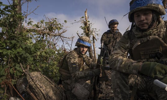 A group of soldiers sit in a field