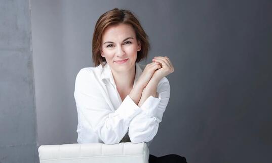 Conductor Daniela Candillari wearing white shirt with hands clasped