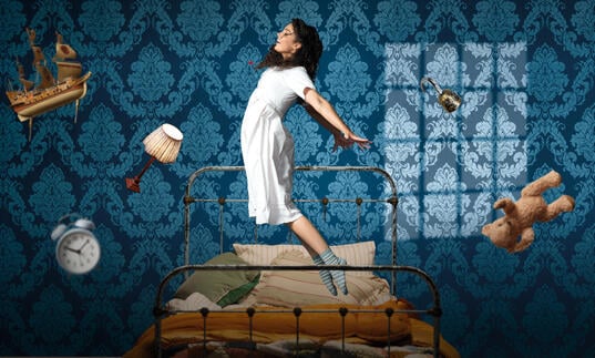 A person starts to fly in the air, levitating above their bed