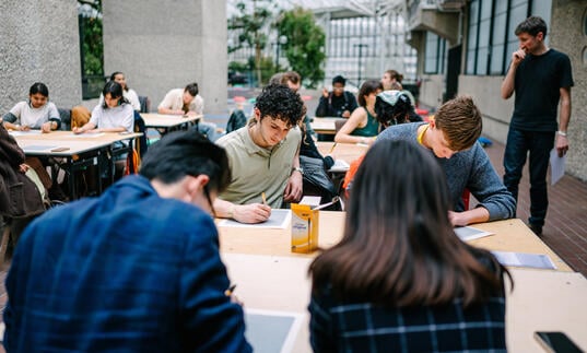 A group of people drawing, engaged in a workshop