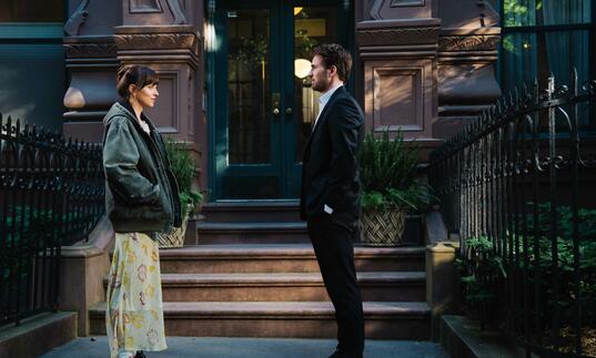 A man and a woman facing each other on the street.