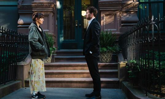 Dakota Johnson and Chris Evans stand on a NYC street