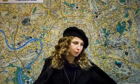 Portrait of Maria Alyokhina against a background of a map